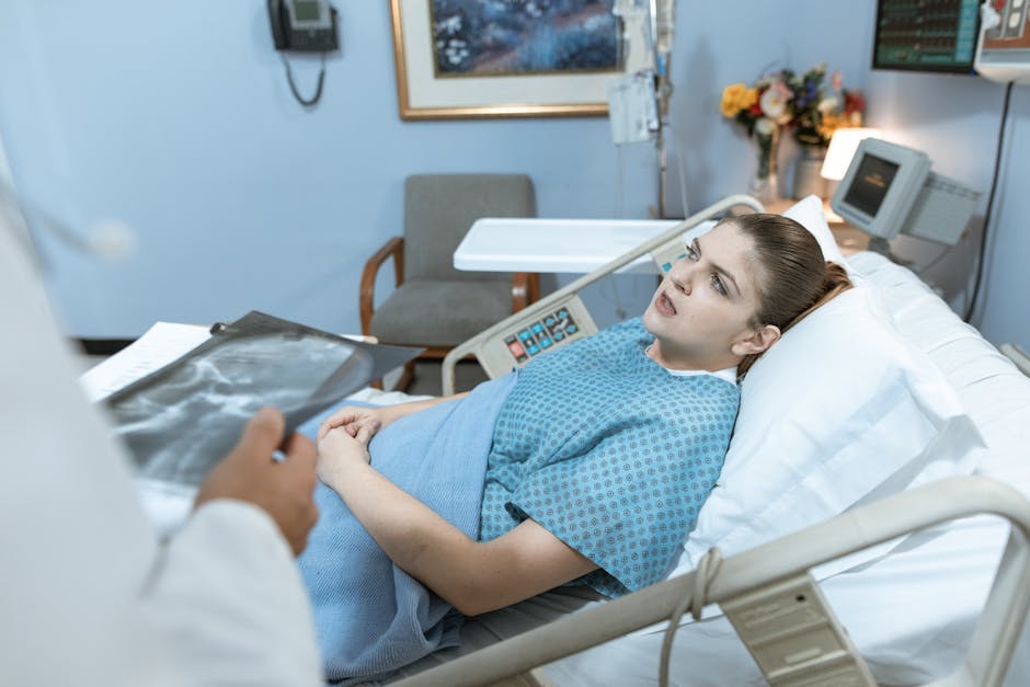 Caucasian woman in hospital bed receiving care from healthcare professional.